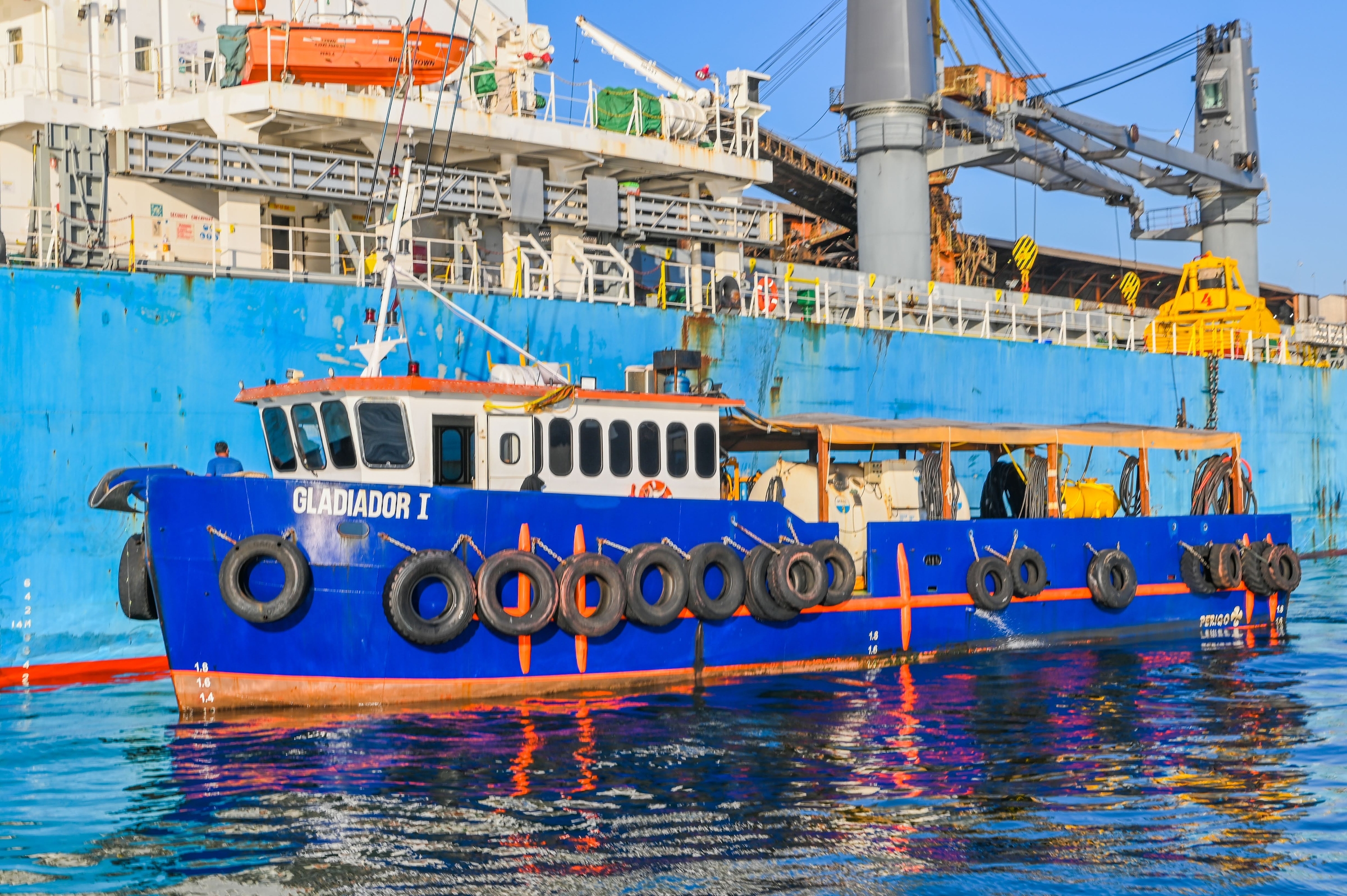 Embarcação Gladiador I ao costado de um navio graneleiro